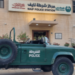 Green Dubai Police vehicle parked in front of Naif Police Station in Deira, UAE.