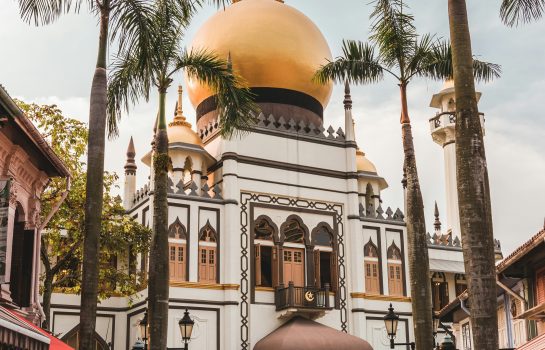 Beautiful golden dome of Masjid Sultan (Sultan Mosque) in Singapore with palm trees and tourists