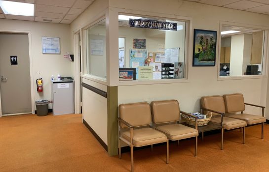Interior of a 24 hour clinic waiting room in Singapore showing clean reception area with seating and patient information notices