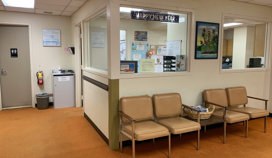Interior of a 24 hour clinic waiting room in Singapore showing clean reception area with seating and patient information notices